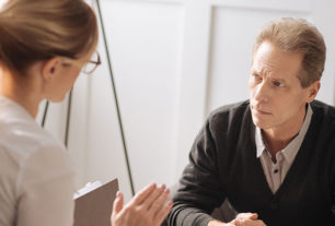 Doctor sat at hr desk with a patient estimating the risk of suicide