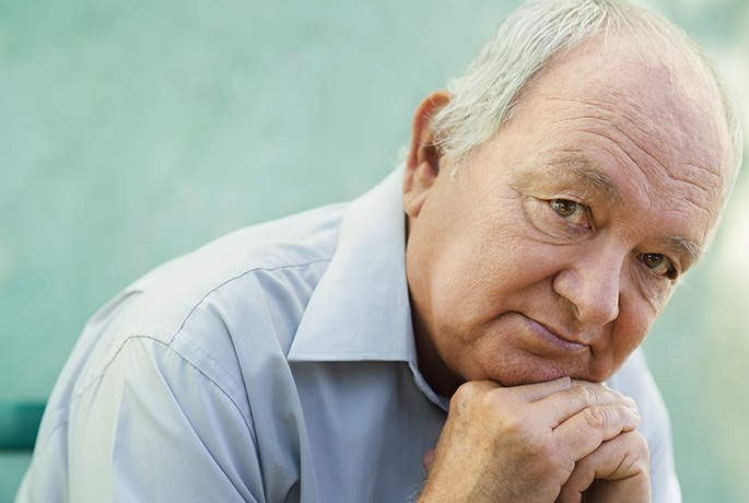 Older man with head on hands thinking about suicide warning signs