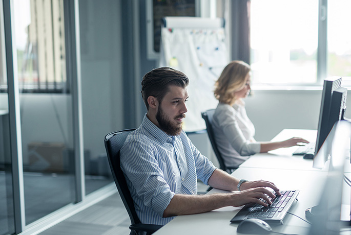 Man looking happy taking care sat at his desk at work