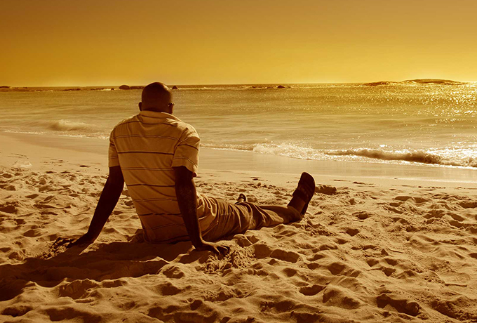 Man sat practicing mindfulness on a beach