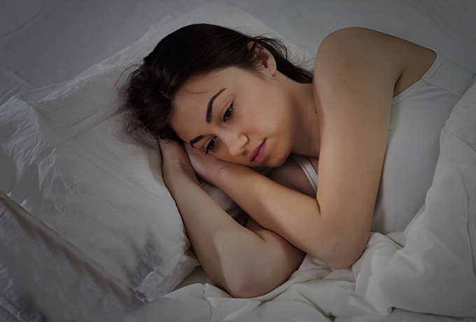 Women laying awake in bed
