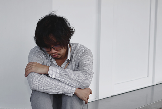 lonely man sitting alone in a corridor