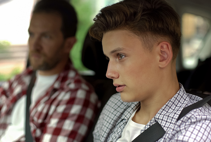 Father talking with son whilst driving