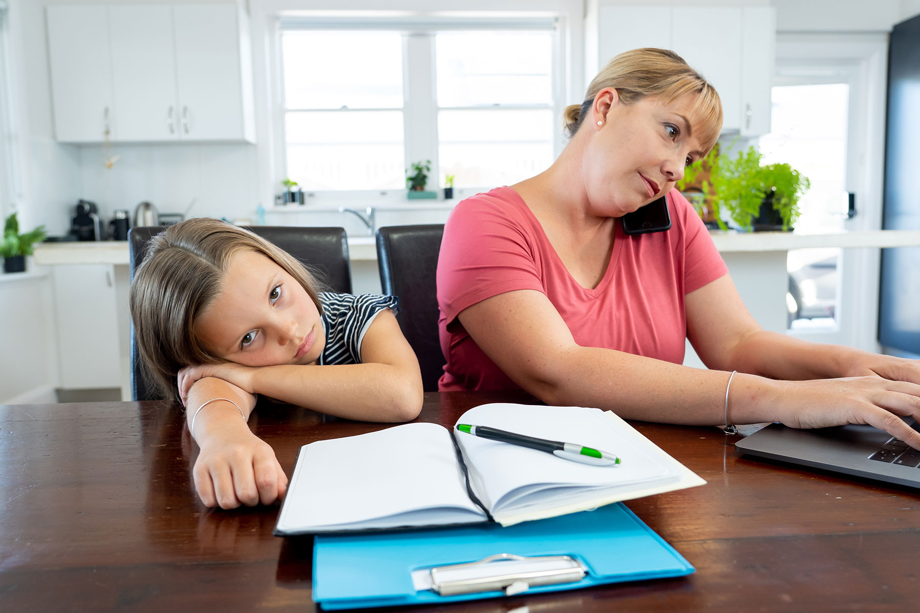 Young mother and daughter working from home