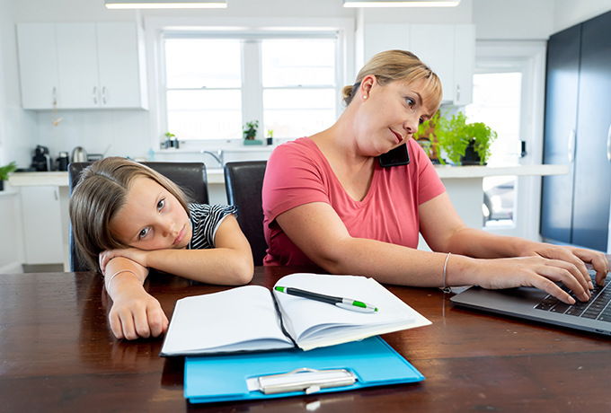 Young mother and daughter working from home