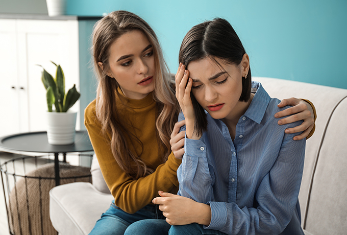 A women sat comforting her friend