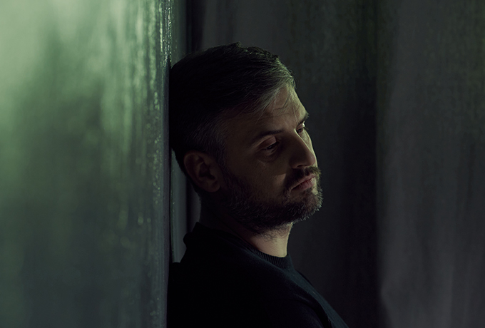 Man leaning against a wall