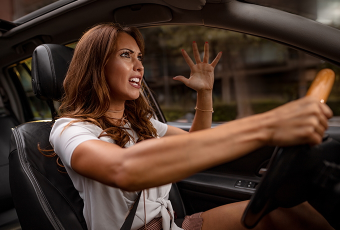 A woman driving, getting angry