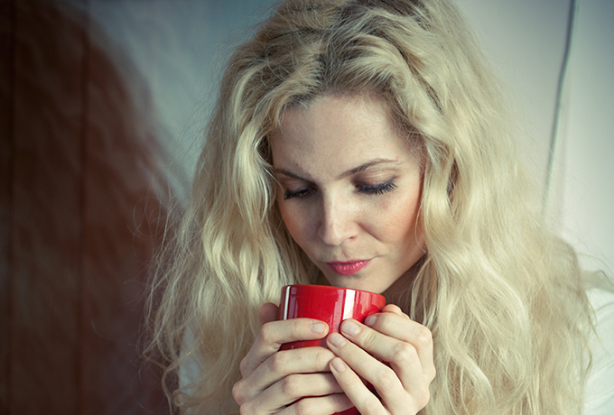 sad struggling woman drinking a cup of tea