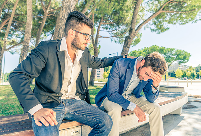 Two men sat together on a park bench